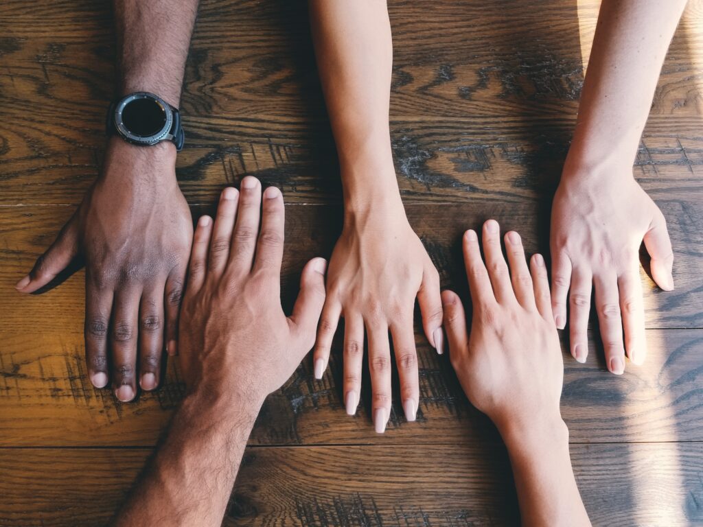 five hands sitting flat on a table